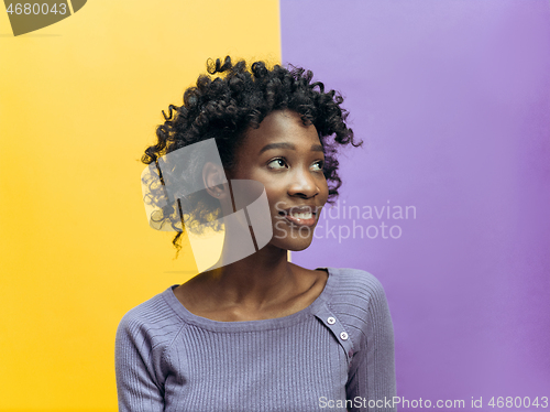 Image of The happy african woman standing and smiling against gray background.