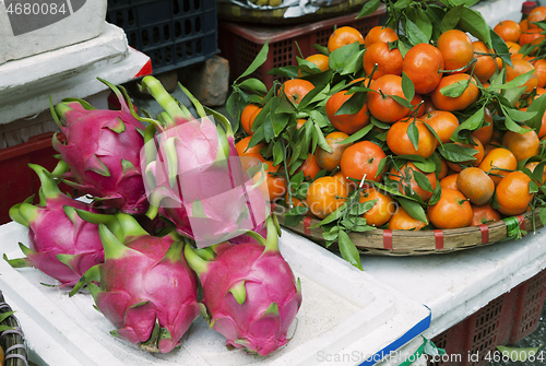 Image of Dragon fruits and tangerines at a market in Vietnam