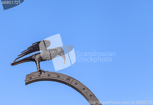 Image of Raven carrying a gold ring near Royal Palace of Budapest