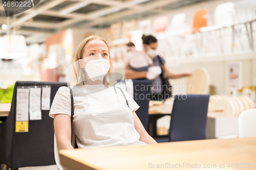 Image of New normal during covid epidemic. Caucasian woman shopping at retail furniture and home accessories store wearing protective medical face mask to prevent spreading of corona virus