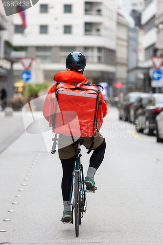 Image of Courier On Bicycle Delivering Food In City.