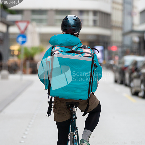 Image of Courier On Bicycle Delivering Food In City.