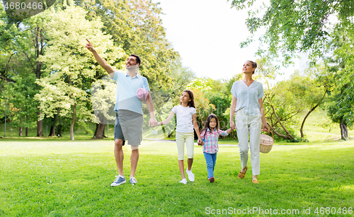 Image of family with picnic basket walking in summer park