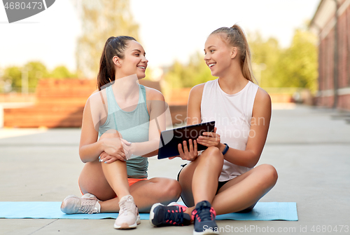 Image of sporty women or friends with tablet pc on rooftop