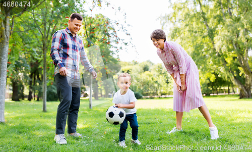 Image of happy family playing soccer at summer park