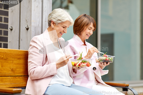 Image of senior women eating takeaway food on city street