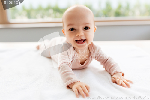 Image of sweet baby girl lying on white blanket