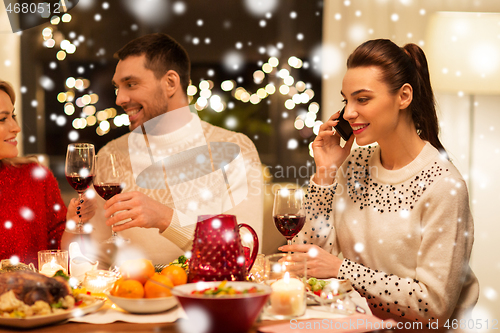 Image of happy friends having christmas dinner at home