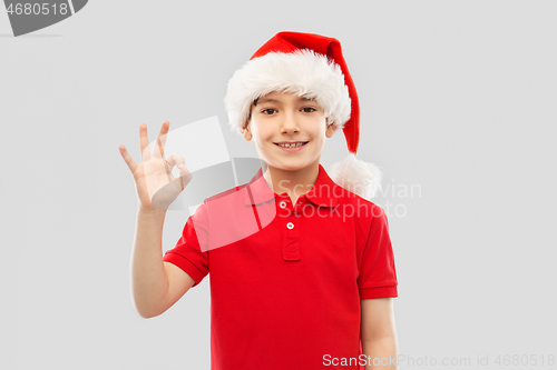 Image of smiling boy in santa helper hat showing ok gesture