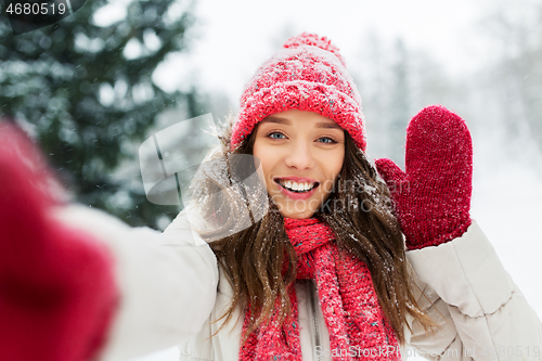 Image of smiling woman taking selfie outdoors in winter