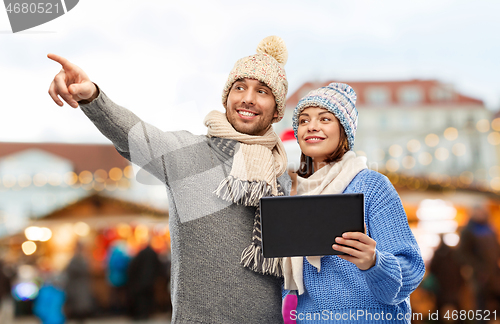 Image of couple with tablet computer at christmas market