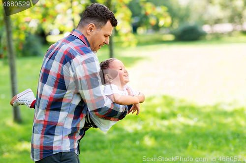 Image of happy father with son playing in summer park