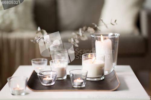 Image of burning fragrance candles on table at cozy home