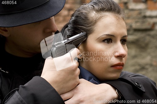 Image of man threatens the woman with a pistol