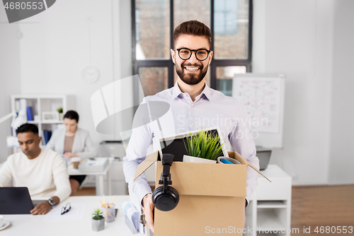 Image of happy male office worker with personal stuff