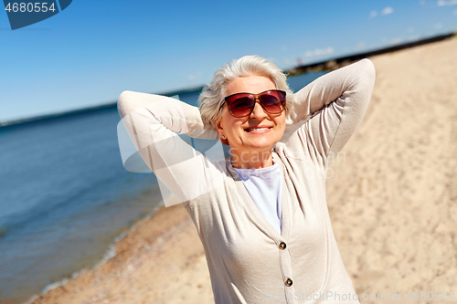 Image of portrait of senior woman in sunglasses on beach