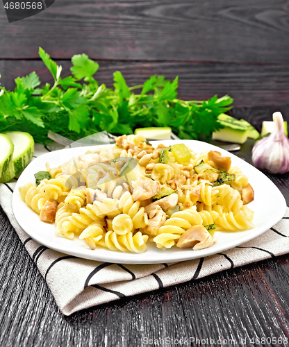 Image of Fusilli with chicken and zucchini in plate on linen napkin