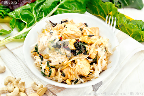 Image of Funchoza with chard and cashew in bowl on napkin