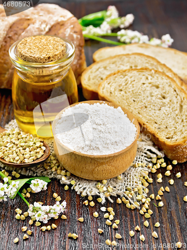 Image of Flour buckwheat green in bowl with bread on dark wooden board