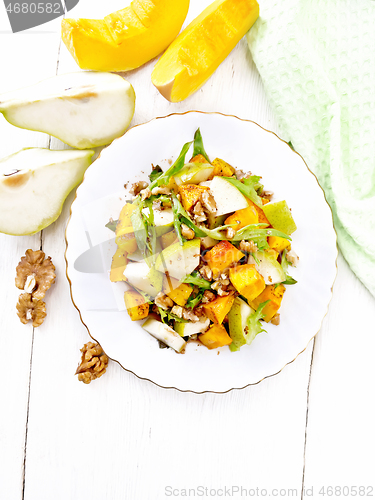 Image of Salad of pumpkin and pear in plate on light board top