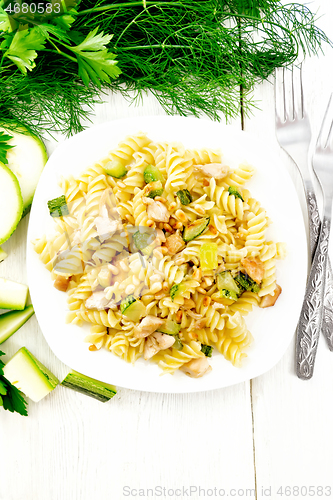 Image of Fusilli with chicken and zucchini in plate on light board top