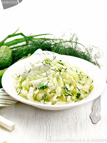 Image of Salad of cabbage with cucumber in plate on white board