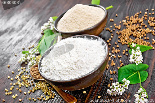 Image of Flour buckwheat green and brown in bowls with flowers on wooden 