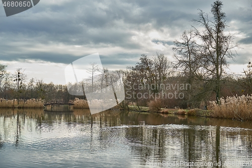 Image of Autumn water surface with trees, cloudy weather