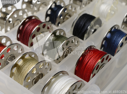 Image of metal bobbins with multi-colored threads