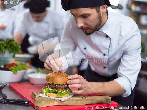 Image of chef finishing burger