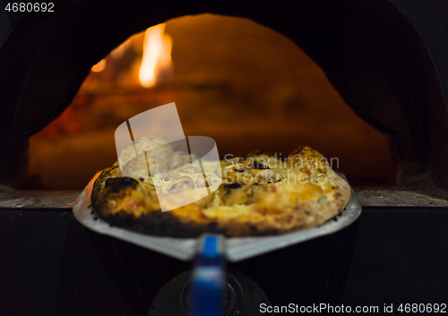 Image of chef removing hot pizza from stove