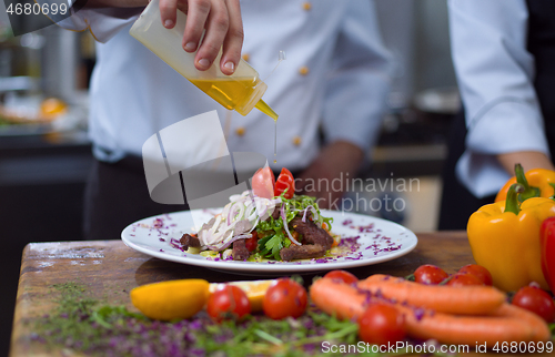 Image of Chef finishing steak meat plate