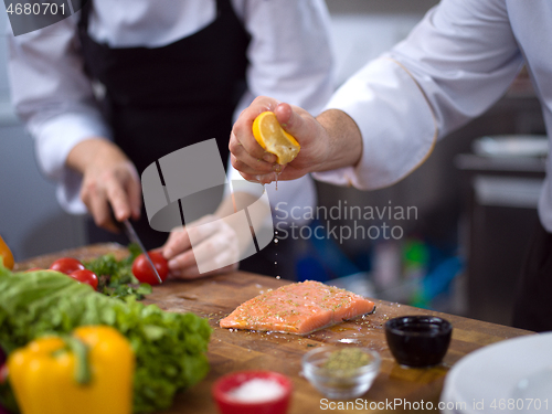 Image of Chef hands preparing marinated Salmon fish