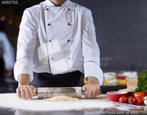 Image of chef preparing dough for pizza with rolling pin