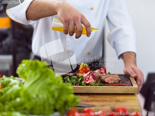 Image of Chef finishing steak meat plate