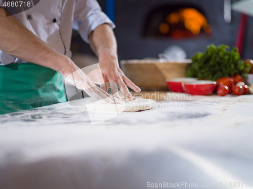 Image of chef preparing dough for pizza