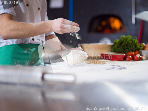 Image of chef hands preparing dough for pizza