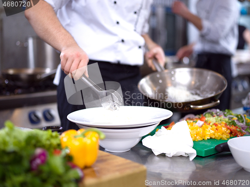 Image of Chef hands serving spaghetti