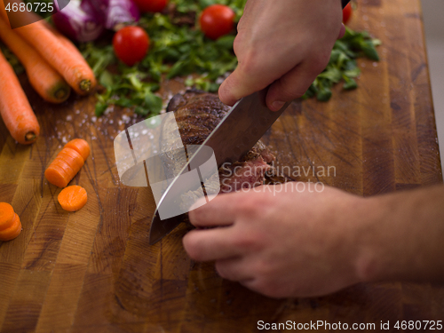 Image of closeup of Chef hands preparing beef steak