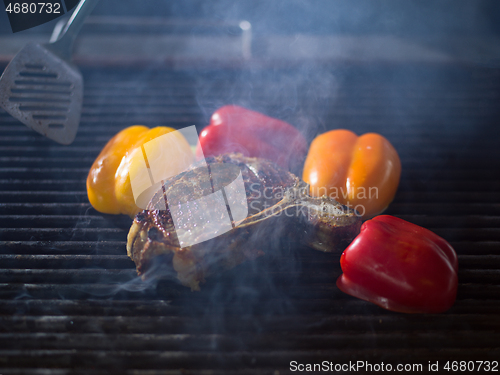 Image of chef cooking steak with vegetables on a barbecue