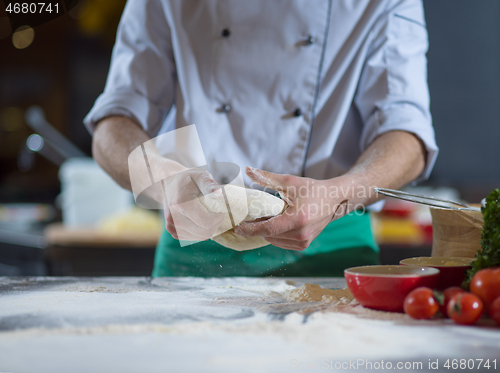 Image of chef hands preparing dough for pizza