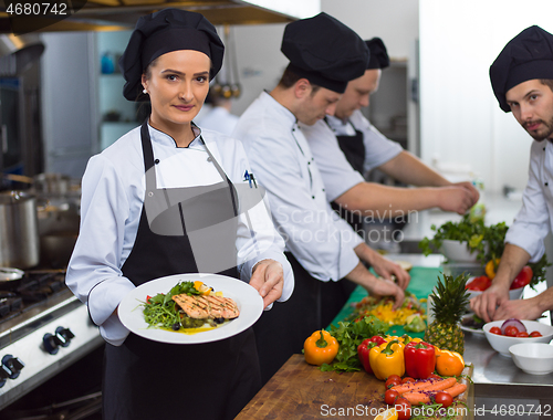 Image of Chef holding dish of fried Salmon fish fillet