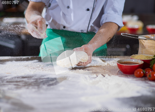 Image of chef hands preparing dough for pizza