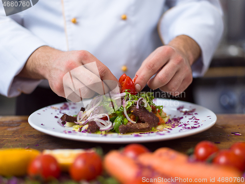 Image of cook chef decorating garnishing prepared meal