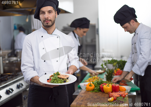 Image of Chef holding dish of fried Salmon fish fillet