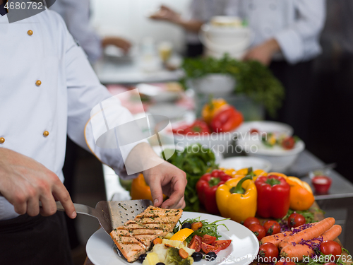 Image of cook chef decorating garnishing prepared meal