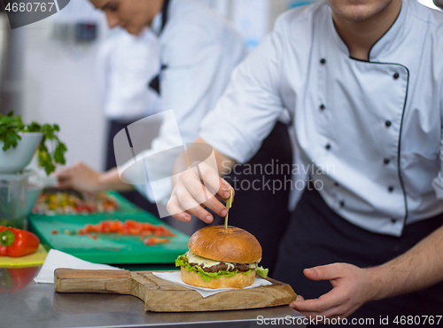 Image of chef finishing burger