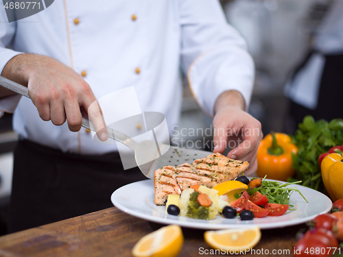 Image of cook chef decorating garnishing prepared meal