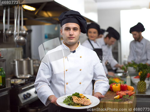 Image of Chef holding dish of fried Salmon fish fillet