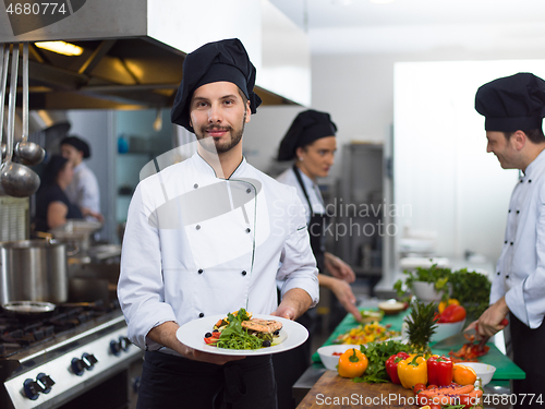 Image of Chef holding dish of fried Salmon fish fillet